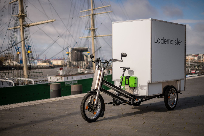 Schwarzes Lastenfahrrad mit großer weißer Transportbox steht im Hafen Hamburg Deutschland